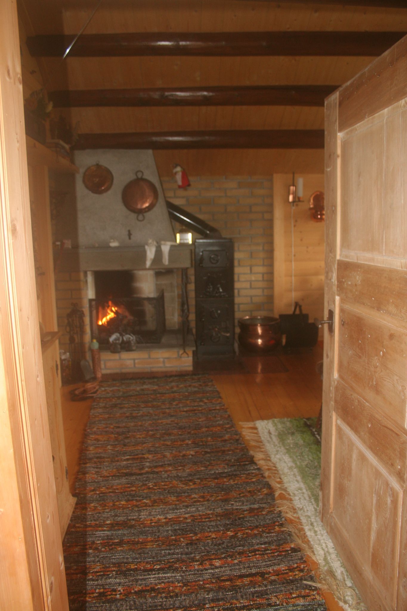 Sfeervolle woonkamer met open haard en veel houten details